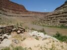 The view of a river trip camp in the distance with brown canyon walls rising on either side of the river
